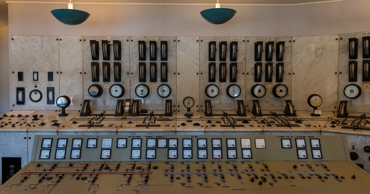 Sala de control industrial con paneles de instrumentos y medidores, capa de supervisión de un sistema de control OT