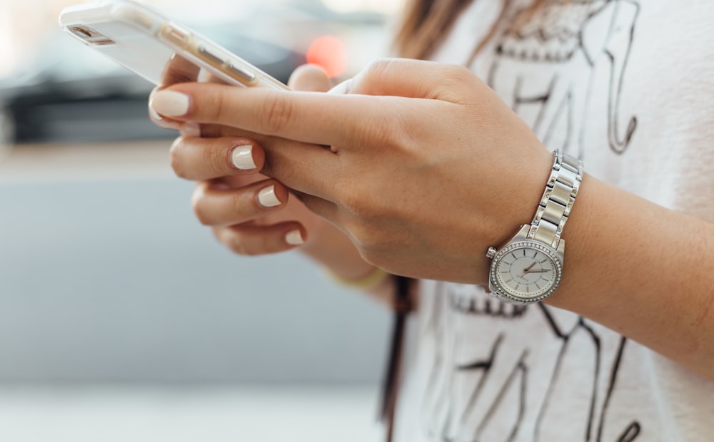 Persona usando un teléfono inteligente, usuaria de servicios públicos de telecomunicaciones